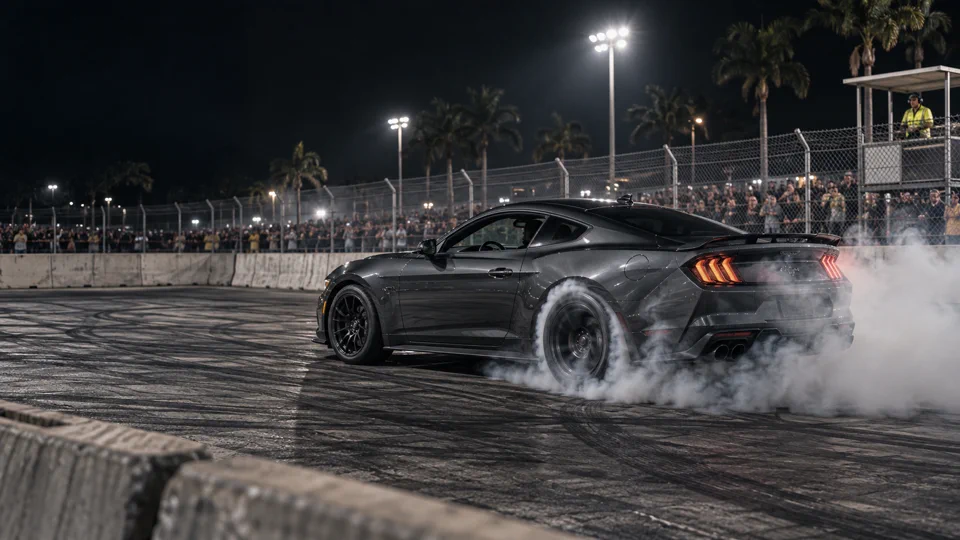 A graphite car doing a controlled burnout on a closed pad